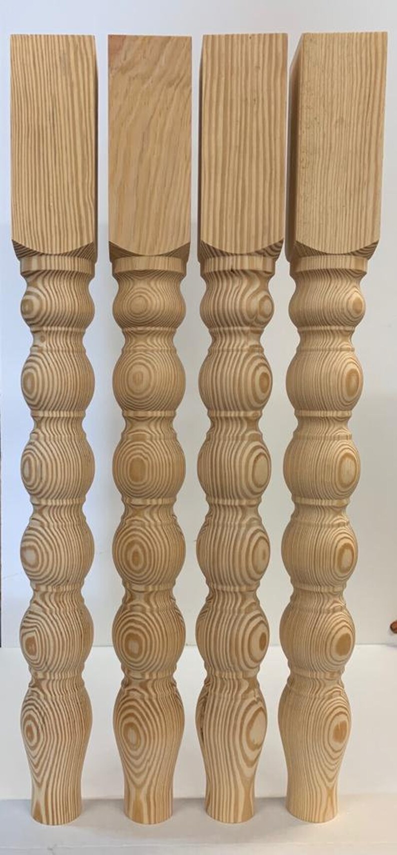 Puede incluir: Cuatro patas de mesa de madera sin terminar con un dise&ntilde;o torneado y bulboso. Las patas son de madera clara con un patr&oacute;n de veta natural.