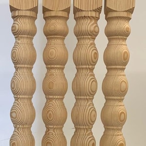 Puede incluir: Cuatro patas de mesa de madera torneada con un dise&ntilde;o decorativo, redondeado y bulboso. Las patas son de madera marr&oacute;n claro con un patr&oacute;n de veta natural.