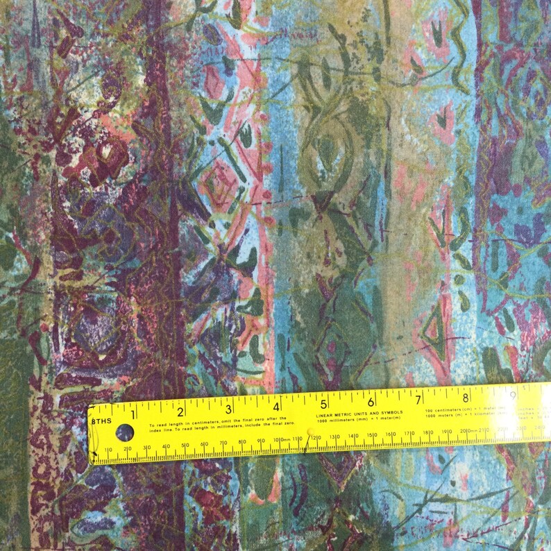 Puede incluir: Tela con estampado abstracto con una regla amarilla que mide 20 cm. La tela tiene un esquema de color verde, azul y rosa.