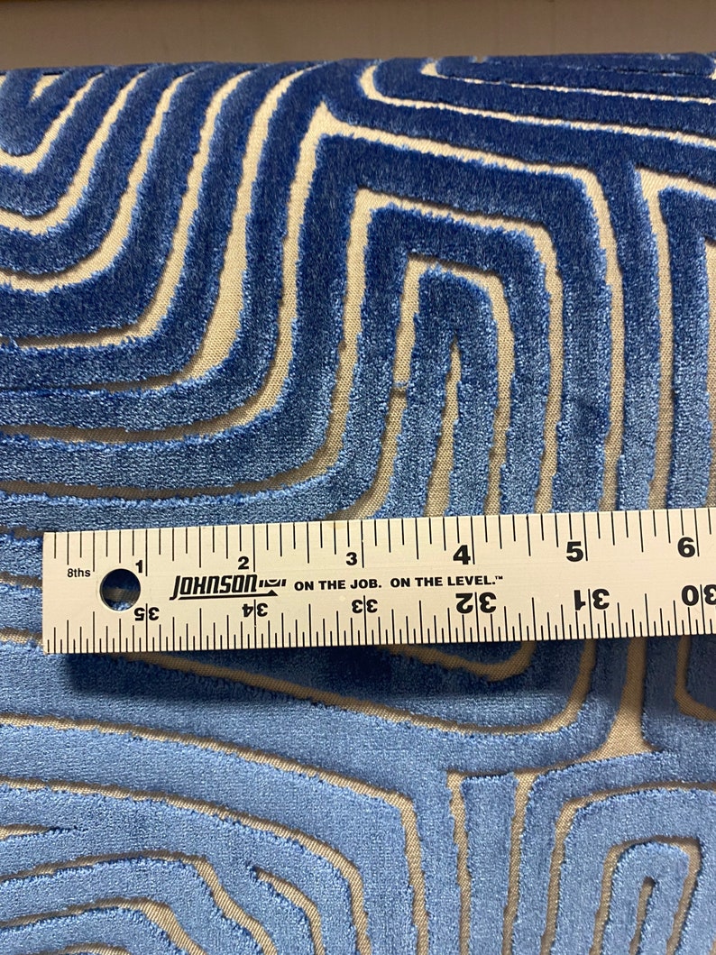 May include: A close-up of a blue and cream patterned fabric with a ruler measuring 6 inches. The fabric has a raised, textured design.
