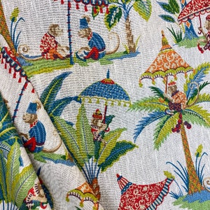 May include: Textile fabric with a whimsical jungle scene featuring monkeys, palm trees, and ornate umbrellas in shades of red, blue, green, and orange. The fabric has a textured, off-white background.