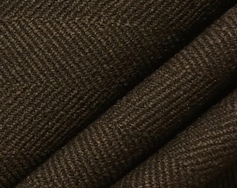 May include: Close-up of a dark brown fabric with a subtle herringbone pattern. The fabric has a textured surface and a slightly rough feel.