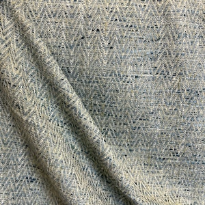 May include: A blue and beige fabric with a chevron pattern. The fabric has a subtle sheen and a textured surface.