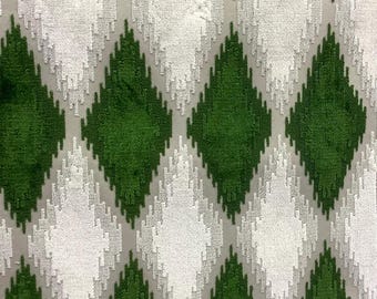 May include: Close-up of a fabric with a repeating diamond pattern. The diamonds alternate between a vibrant green and a textured white. The background is a light gray, creating a subtle contrast. The fabric has a soft, plush appearance.