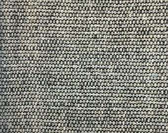 May include: Close-up of a woven fabric with a textured appearance. The fabric is a mix of black and white threads, creating a speckled, grayscale pattern. The weave is tight, showing a durable textile.
