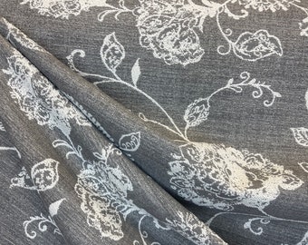 May include: Gray fabric with a white floral pattern. The fabric has a textured surface and a subtle sheen.
