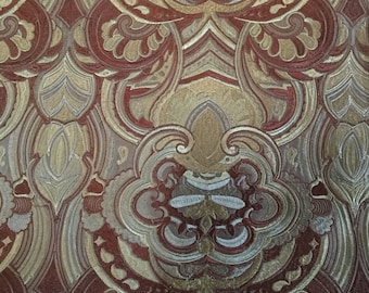 Peut inclure: Gros plan sur un tissu rouge et or à motif paisley. Le tissu a une texture douce et veloutée.