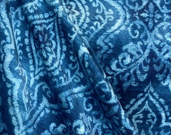May include: Blue fabric with a white damask pattern. The fabric is folded and has a textured surface.