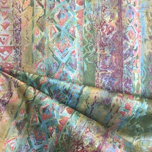 Puede incluir: Tela estampada abstracta con un esquema de color azul, verde y rosa. La tela tiene un aspecto texturizado, pintado a mano.