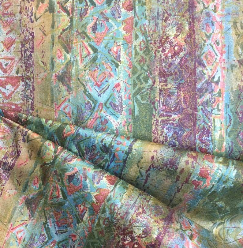 Puede incluir: Tela estampada abstracta con un esquema de color azul, verde y rosa. La tela tiene un aspecto texturizado, pintado a mano.