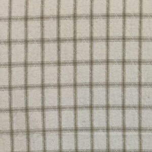 May include: A close-up of a white fabric with a brown checkered pattern.