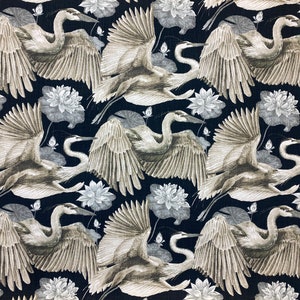 May include: A black fabric with a repeating pattern of white lotus flowers and gray herons with outstretched wings.