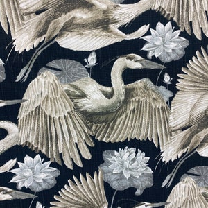 May include: A black fabric with a repeating pattern of white and gray stylized illustrations of herons and lotus flowers.