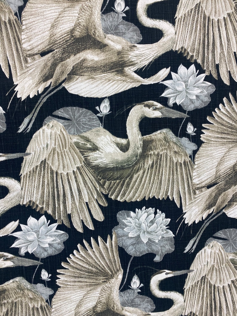 May include: A black fabric with a repeating pattern of white and gray stylized illustrations of herons and lotus flowers.