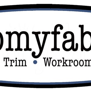 Op de afbeelding: Een wit bord met een zwarte rand en blauwe versiering. Het bord heeft de tekst "shopmyfabrics" in een zwart serif-lettertype. Onder de tekst staat "Fabric &bull; Trim &bull; Workroom Services".