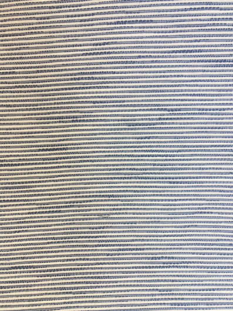 May include: A close-up of a woven fabric with horizontal stripes in shades of white and blue.
