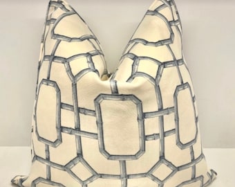 May include: A white pillow with a blue geometric pattern. The pattern resembles a chain link fence or a bamboo lattice.