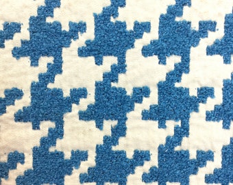 May include: A white fabric with a blue geometric pattern. The pattern is a repeating design of small squares and rectangles.