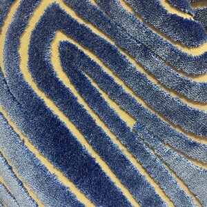 May include: Blue and beige fabric with a wavy, striped pattern. The fabric has a textured, fuzzy surface.