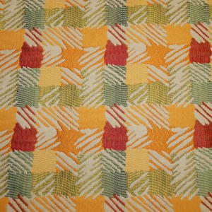 May include: Close-up of a woven fabric with a repeating pattern of squares. The squares are filled with a mix of colors including orange, yellow, green, and red. Diagonal lines create a textured effect.