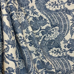 May include: Blue and white floral patterned fabric with a linen texture. The fabric has a repeating pattern of stylized flowers and leaves.