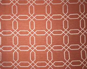 May include: A close-up of a fabric with a repeating geometric pattern. The fabric is a light orange color with a white geometric pattern.