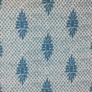 Puede incluir: Una tela azul turquesa con un patr&oacute;n repetitivo de un dise&ntilde;o de flor estilizado. La tela tiene un fondo blanco y un sutil patr&oacute;n de cuadr&iacute;cula.