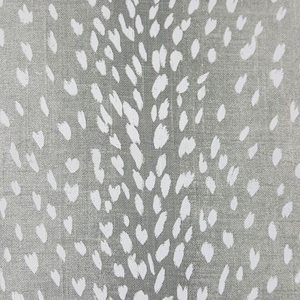 May include: A close-up of a gray fabric with a white, abstract, speckled pattern. The pattern resembles a deer's spots.