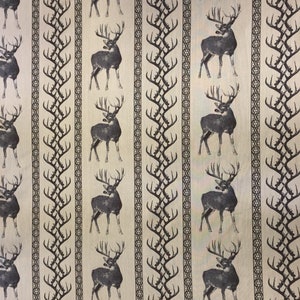 May include: A beige fabric with a repeating pattern of black deer silhouettes and stylized antlers. The deer are facing right and have large antlers. The background is a light beige color.