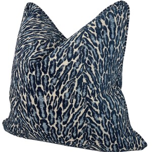 May include: A blue and white patterned cushion with a leopard print design.