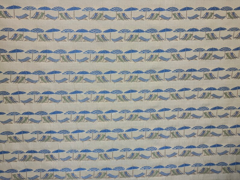 May include: A beige fabric with a repeating pattern of blue and white striped umbrellas and green lounge chairs.