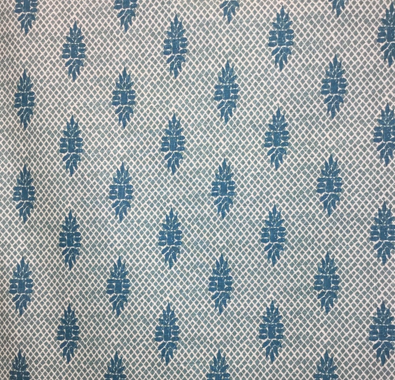 Puede incluir: Una tela blanca con un patr&oacute;n repetitivo de rombos azules. Los rombos est&aacute;n rellenos de un dise&ntilde;o floral estilizado.