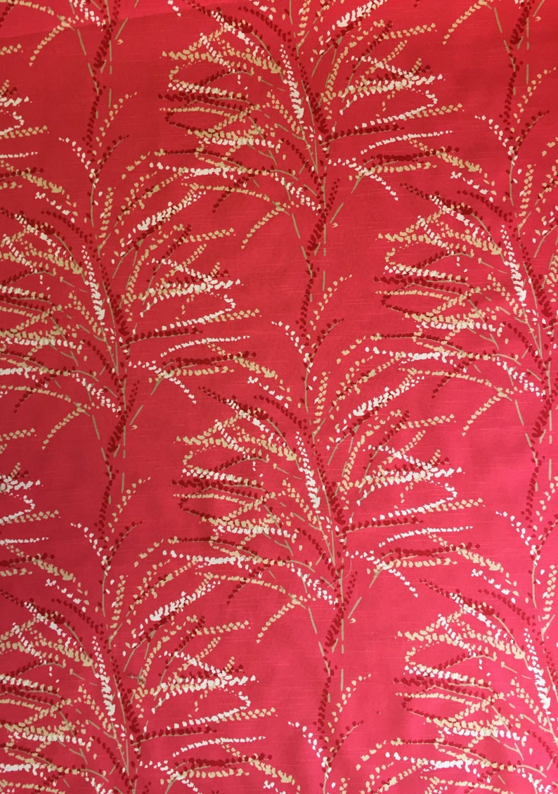 May include: Red fabric with a white and brown floral pattern. The pattern features delicate branches with small white and brown dots.