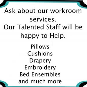 May include: A teal and black sign with the text "Ask about our workroom services. Our Talented Staff will be happy to Help. Pillows, Cushions, Drapery, Embroidery, Bed Ensembles and much more"