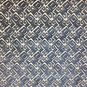 May include: A repeating pattern of dark blue and off-white geometric shapes. The design features a series of interconnected squares and stylized scroll-like elements, creating a textured, all-over print. The pattern has a watercolor-like effect.