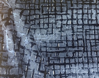 May include: Close-up of a textured fabric with a grid-like pattern. The fabric is primarily a dark blue color with lighter blue and silver accents. The pattern creates a geometric, almost mosaic-like effect.