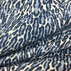 May include: Blue and white patterned fabric with a textured, animal print design.