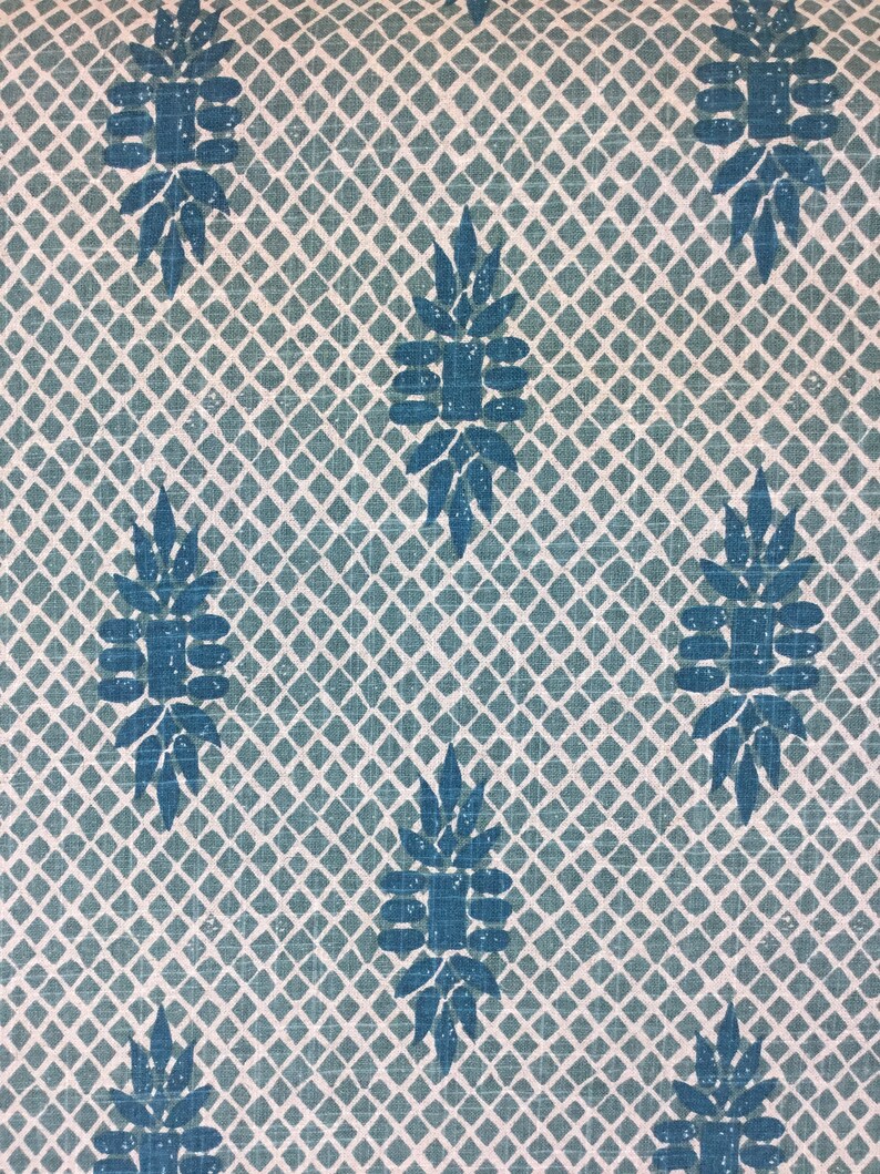 Puede incluir: Una tela azul turquesa con un patr&oacute;n repetitivo de dise&ntilde;os florales estilizados sobre un fondo blanco. La tela tiene un sutil patr&oacute;n de cuadr&iacute;cula.
