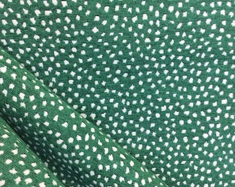 May include: Green fabric with a white polka dot pattern. The fabric is folded in half, showing the pattern on both sides.