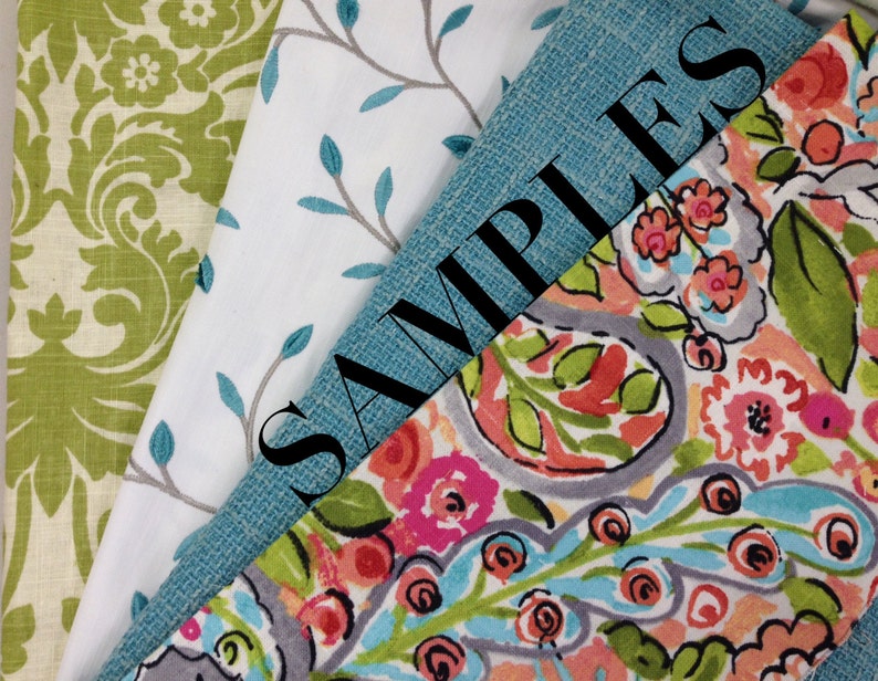 May include: Four fabric swatches, one with a green floral pattern, one with a white background and gray branches, one with a blue and green paisley pattern, and one with a solid blue color. The blue swatch has the word "SAMPLES" written in black.