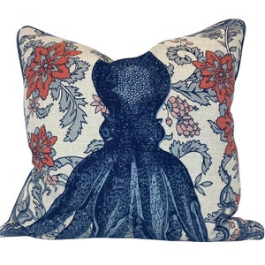 May include: A decorative pillow with a blue octopus print on a white background with red and blue floral designs.