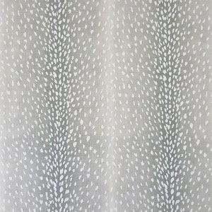 May include: A close-up of a gray fabric with a white spotted pattern. The fabric has a subtle texture and a soft, muted color.