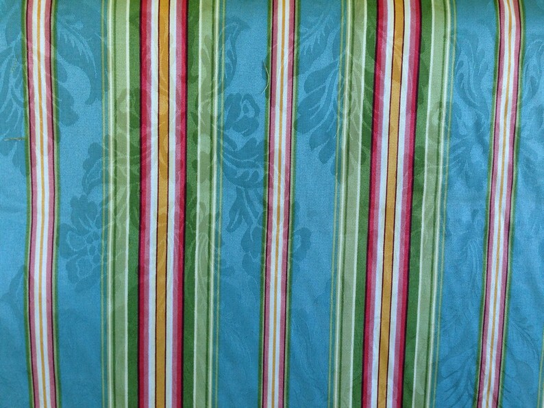 May include: Striped fabric with alternating blue, green, yellow, pink, and white stripes. The fabric has a subtle floral pattern.