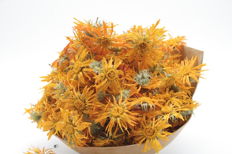 May include: A bunch of dried orange and yellow calendula flowers in a brown paper bag.