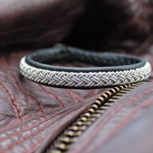 Sami bracelet LEIPT handmade in Black genuine leather and tin wire.
Label AC Design Sweden
Shown on a leather jacket.
