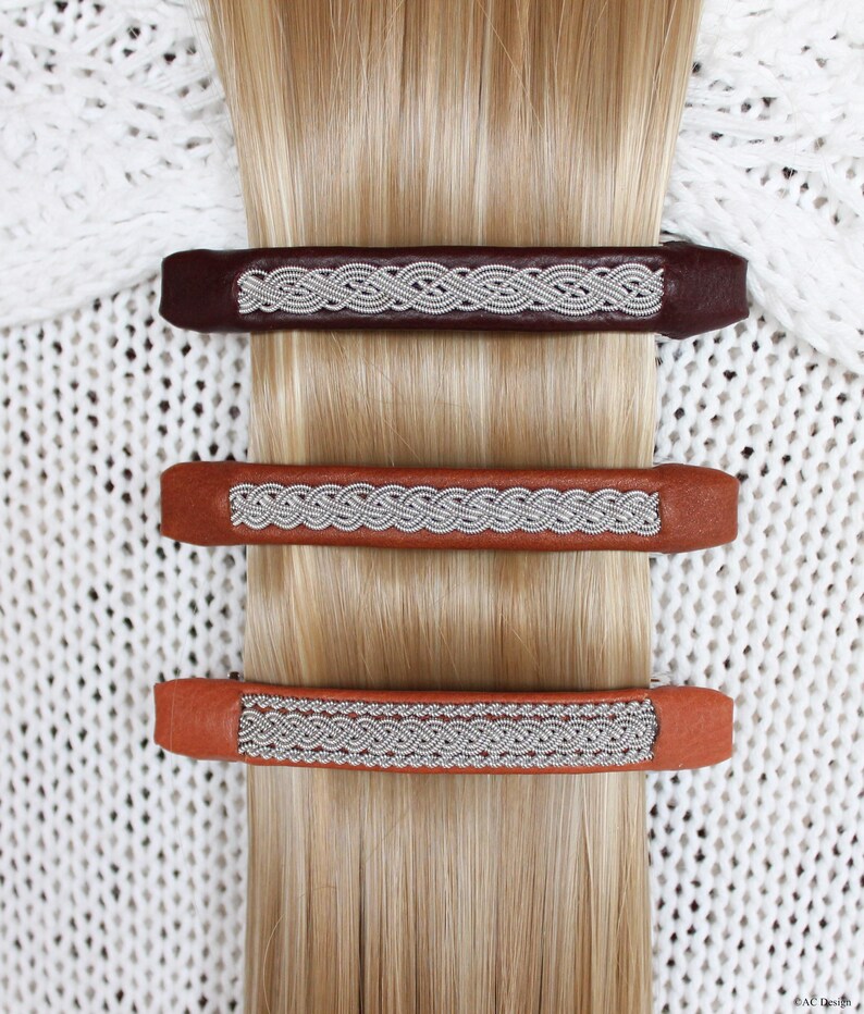 3 Beautiful and unique hair barrette fasten in a long blond hair, abow a white knitted cardigan, made in reindeer leather and braids in pewter wire. 
Hair clips handmade in Sweden by Ann-Cathrine Hedman AC Design. 
Perfect gift!