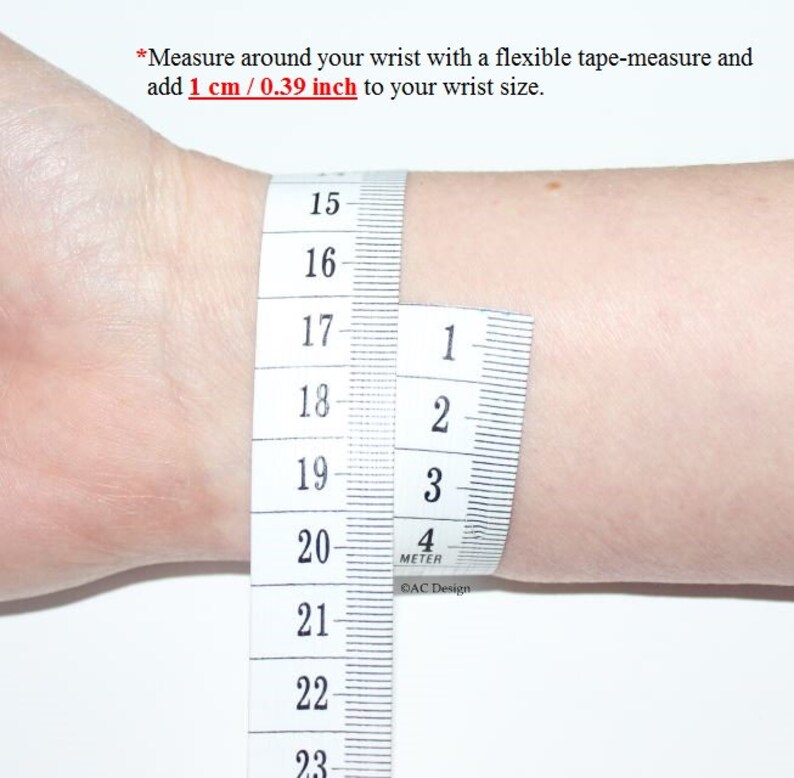 May include: A white tape measure wrapped around a wrist, showing measurements in inches and centimeters. The tape measure reads 15 to 23 inches and 1 to 4 centimeters. The text on the tape measure reads "4 METER" and "AC Design".