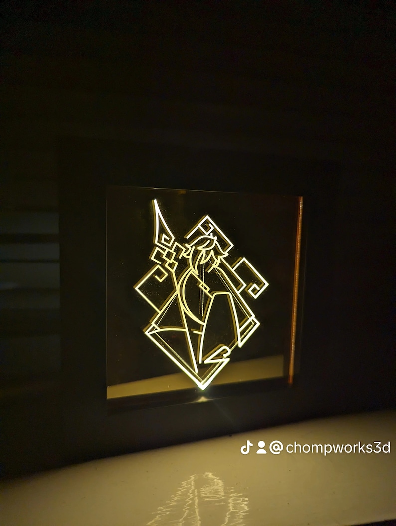 May include: A 3D printed light-up lamp with a geometric design featuring a stylised figure holding a weapon. The lamp is lit up in a warm yellow colour.