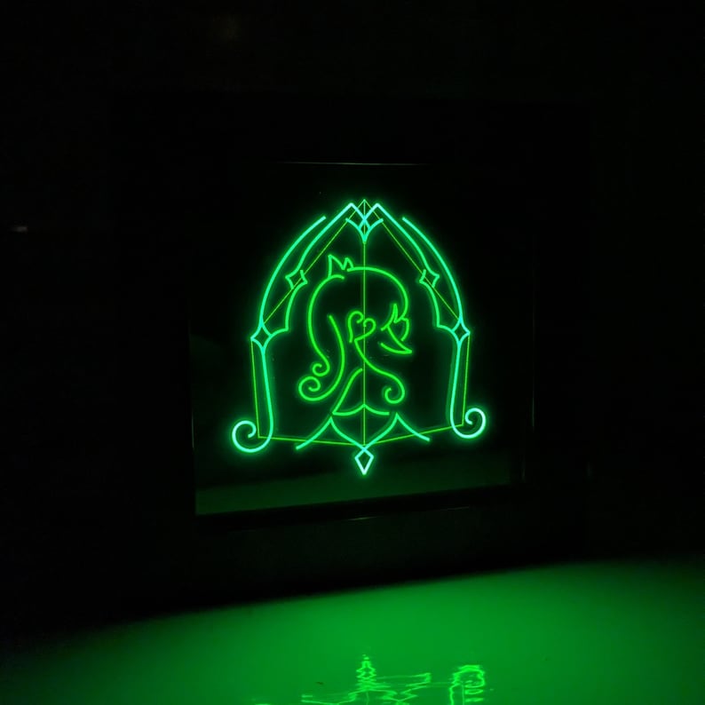 May include: A green neon sign featuring a stylised image of a woman's head within a geometric frame.