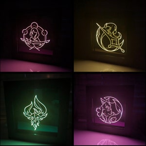 May include: Four different neon signs with various designs. The signs are in black frames and are lit up in different colours. The designs include a woman with a sword, a crescent moon with a sword, a phoenix, and a creature with a crescent moon.